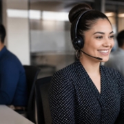 Customer service representative wearing a headset, smiling while engaging with customers, illustrating CX outsourcing benefits in modern business operations.